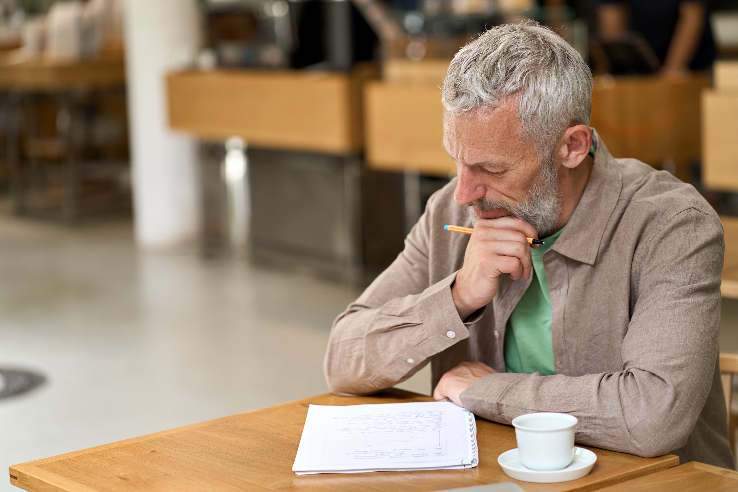 Middle-age man taking notes inside a cafe